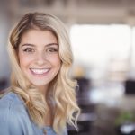 Smiling business woman standing in creative office